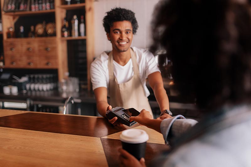 Man making a payment with a debit or credit card in a bakery